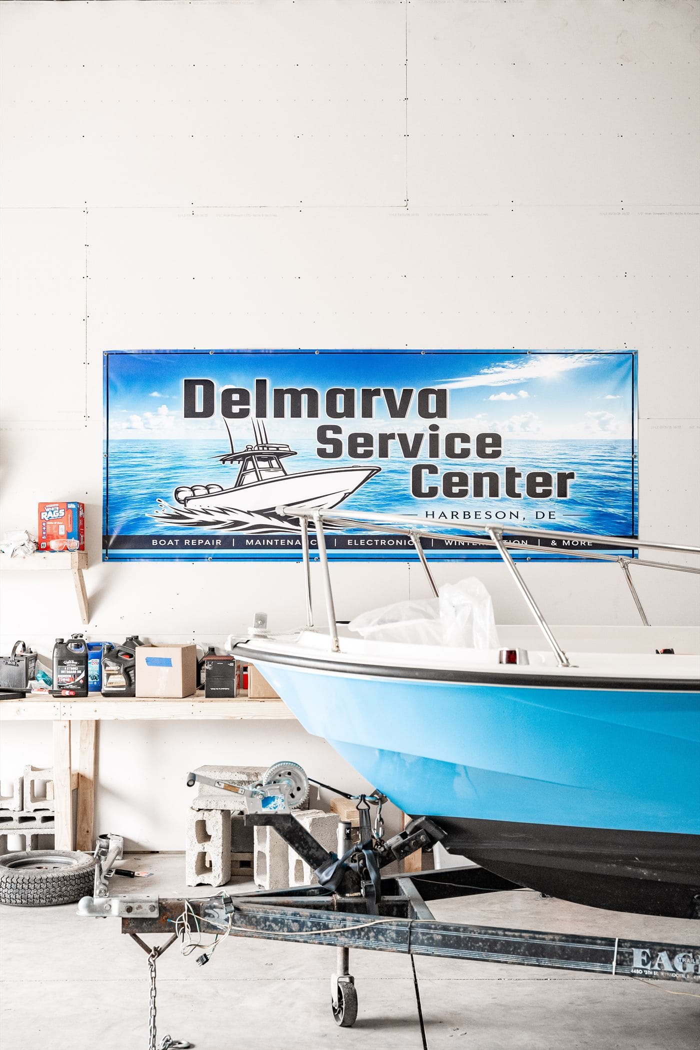 A center console boat inside the shop beneath the Delmarva Service Center banner