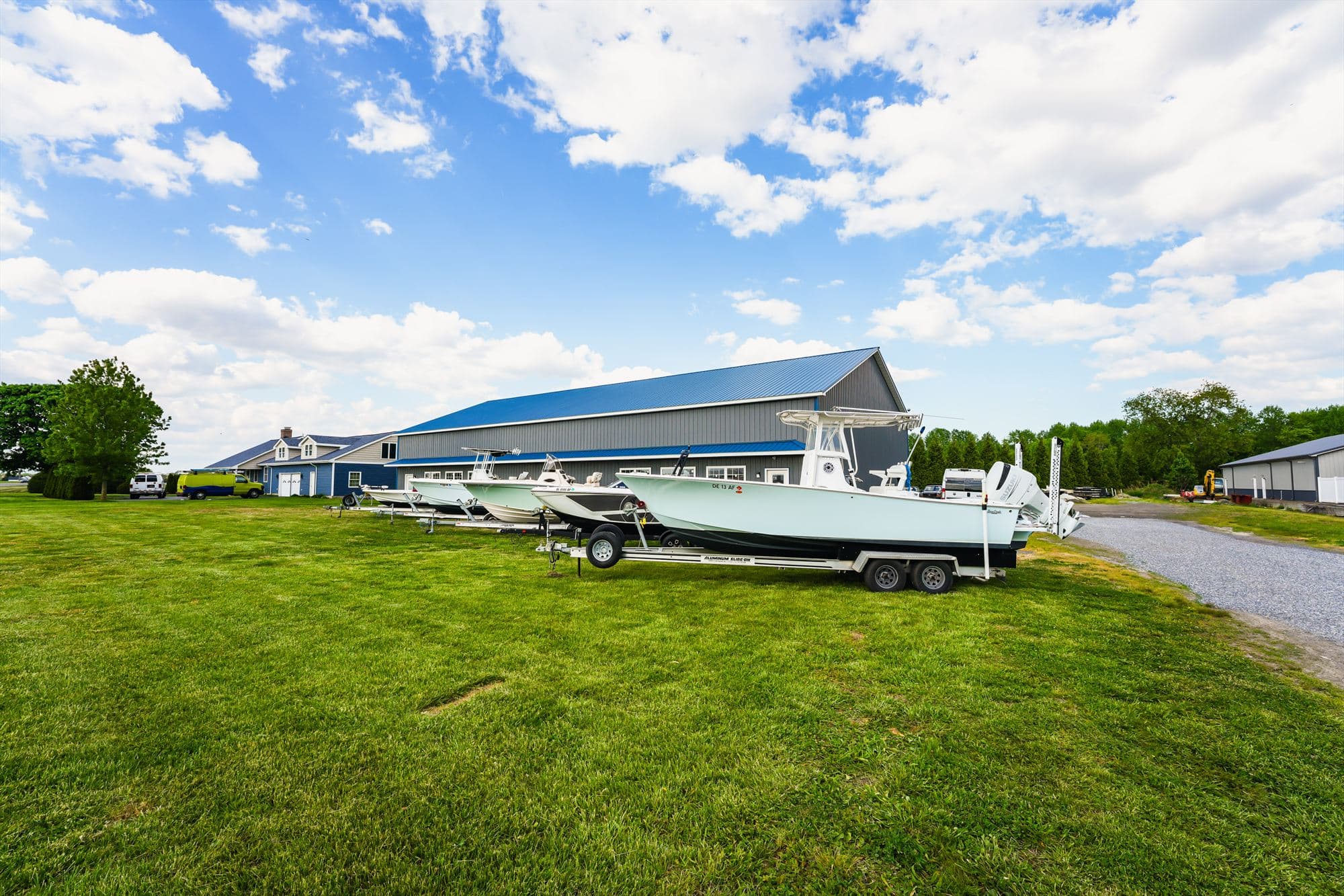 Wide view of the Delmarva Service Center facility and lawn with a center console boat on a trailer