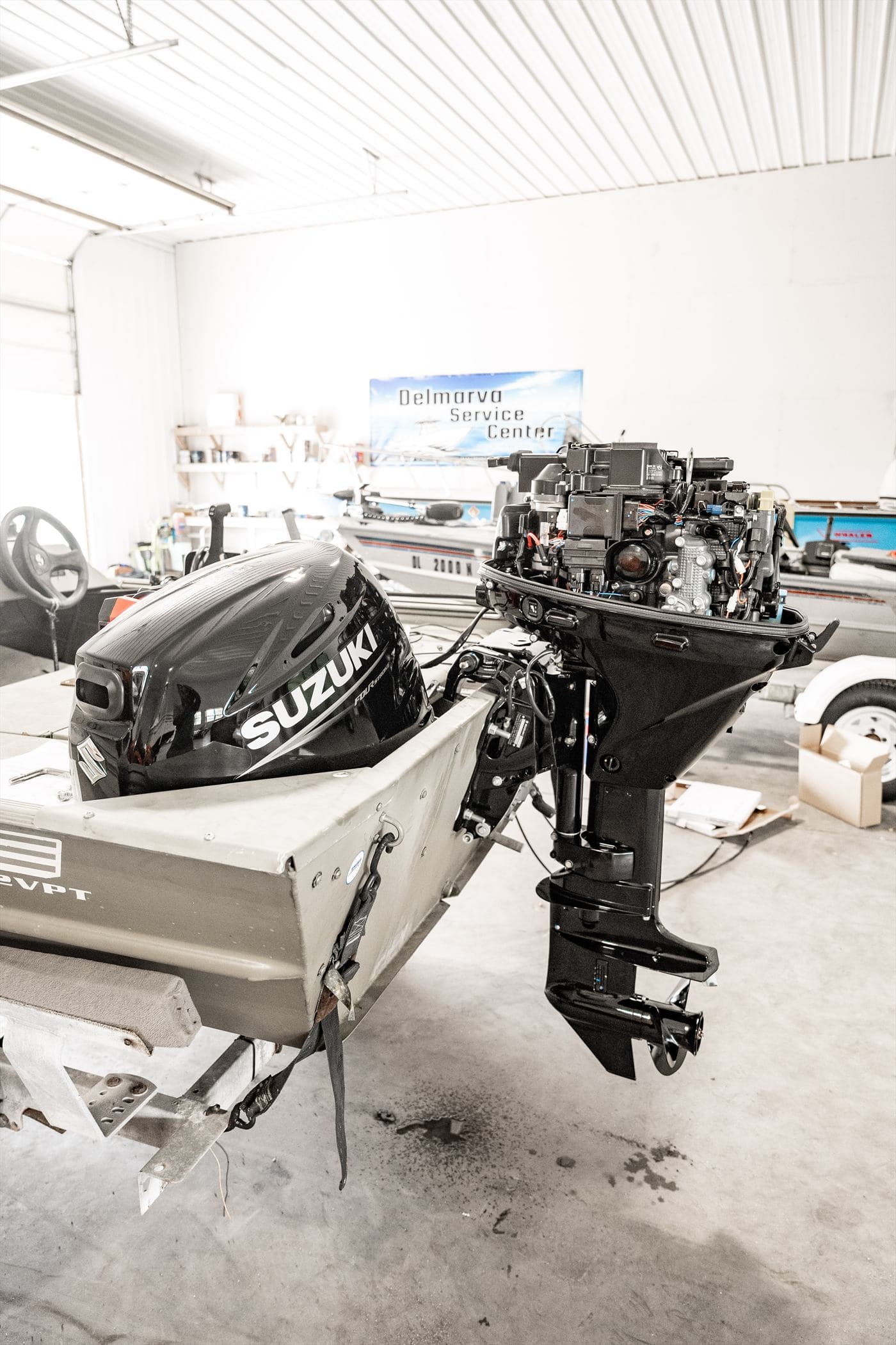 Outboard engine mounted on an aluminum skiff being serviced in the shop